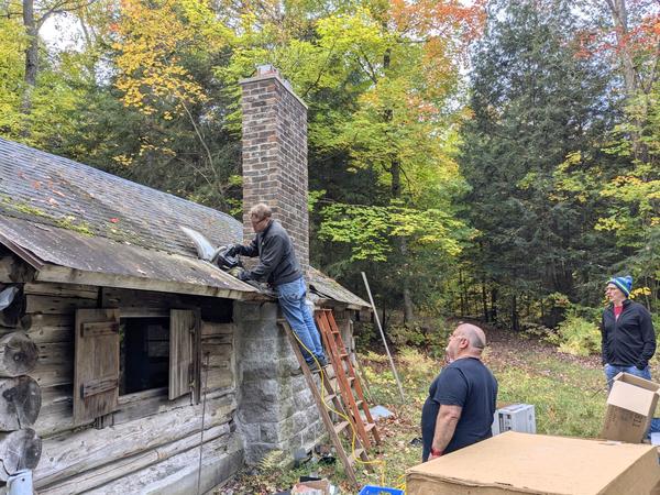 Bill cutting out some old roof with Jon and Ed "supervising".