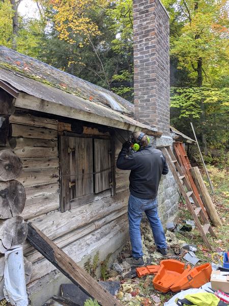 Bill cutting out some of the burnt sill log with a chainsaw.