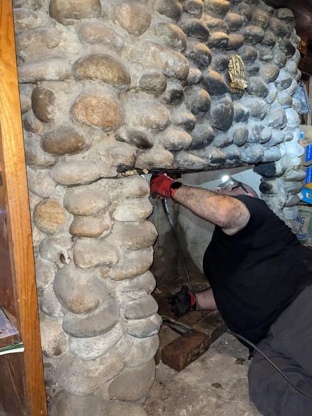 Jon cutting part of the original flue in the firebox to make room for the new flue pipe.
