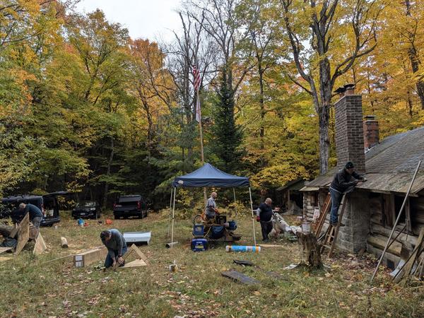 Everyone working on the roof around the chimney.