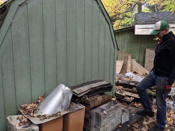 Ed stacking the unused bricks from the old bar on a pallet behind the shed.