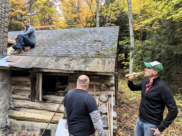 Ed taking a drink of "Old Corn" prior to finishing the install of the roof saddle.