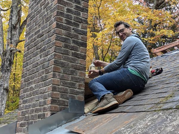 Mikey proudly placing the "Old Corn" as a time capsule in the roof saddle.
