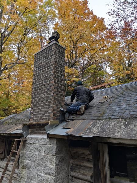 Bill putting the final cap shingles on the roof saddle.