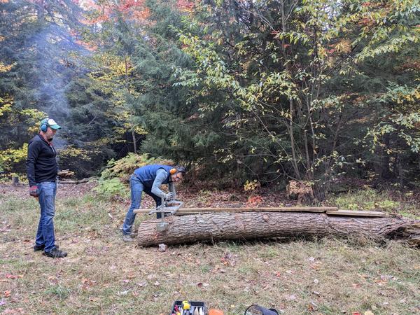Mikey, with Ed, cutting the log using the Alaskan sawmill.