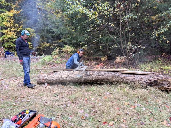 Mikey, with Ed, cutting the log using the Alaskan sawmill.